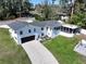 Aerial shot of a two-story home with an attached garage, screened porch, and well-maintained lawn at 1930 Hilltop Dr, Mount Dora, FL 32757