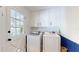 Bright laundry room featuring a washer, dryer, and white cabinetry for storage at 1930 Hilltop Dr, Mount Dora, FL 32757