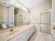 Bathroom with double sinks, a large mirror, and a glass-enclosed shower at 203 Del Rio Drive, Lady Lake, FL 32159