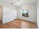 Bedroom with wood floors and a window offering natural light and views of the neighborhood at 203 Del Rio Drive, Lady Lake, FL 32159