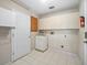 Functional laundry room with white cabinets and tile flooring at 203 Del Rio Drive, Lady Lake, FL 32159