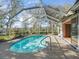 Inviting pool with screened enclosure and access steps, ready for relaxation and enjoyment at 203 Del Rio Drive, Lady Lake, FL 32159