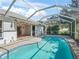 Backyard pool area with screened-in enclosure and covered patio at 203 Del Rio Drive, Lady Lake, FL 32159