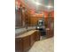 Well-lit kitchen with stainless steel appliances and light countertops, complemented by orange walls and tile floors at 2082 Vision Ct, The Villages, FL 32163