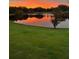 Scenic pond view at sunset reflecting orange and pink sky at 2082 Vision Ct, The Villages, FL 32163