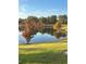 Scenic view of a pond with mature trees in autumn colors, reflecting a serene landscape at 2082 Vision Ct, The Villages, FL 32163