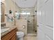 Bathroom featuring glass shower enclosure with travertine tile and granite vanity at 2175 Madero Dr, The Villages, FL 32159