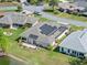 Single-story home features solar panels, a rear patio and landscaping overlooking the serene pond at 21849 Tartan St, Leesburg, FL 34748