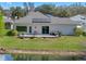 Back of house with Solar Panels and lush green lawn, a patio and views of the pond at 21849 Tartan St, Leesburg, FL 34748