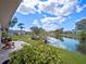 Back patio view with water feature, seating area and lush tropical landscaping at 21849 Tartan St, Leesburg, FL 34748