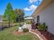 Brick patio with outdoor seating, decorative landscaping, and a peaceful backyard pond at 21849 Tartan St, Leesburg, FL 34748