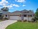 Attractive home featuring an attached two-car garage, paved driveway and lush green lawn at 21849 Tartan St, Leesburg, FL 34748