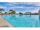 A long outdoor swimming pool on a sunny day, surrounded by lounge chairs and palm trees at 21849 Tartan St, Leesburg, FL 34748