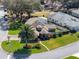 Aerial view featuring vibrant green landscaping, mature trees, and the home's roof with solar panels at 21850 Tartan St, Leesburg, FL 34748