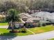 Aerial home view with pristine landscaping, palm trees, and solar panels, complemented by an inviting neighborhood at 21850 Tartan St, Leesburg, FL 34748