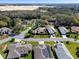 Neighborhood aerial view showing the home, lush landscaping, solar panels, and surrounding homes at 21850 Tartan St, Leesburg, FL 34748