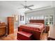 Primary bedroom with hardwood floors, natural light, ceiling fan, and ensuite bathroom at 21850 Tartan St, Leesburg, FL 34748