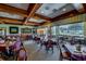 Elegant dining room with tables set for service, wood beam ceilings, and views of the golf course at 21850 Tartan St, Leesburg, FL 34748