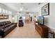 Open-concept living room showcasing tile floors, a ceiling fan, and seamless flow to the kitchen and dining area at 21850 Tartan St, Leesburg, FL 34748