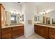 Dual vanities with granite counters and wood cabinetry in this well-lit bathroom at 2279 Lowell Ter, The Villages, FL 32162