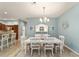 Light-filled dining room with white table, chairs, hutch, and stylish chandelier at 2279 Lowell Ter, The Villages, FL 32162