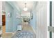 Bright foyer with tile flooring, a bench and a view into living spaces with light-blue painted walls at 2279 Lowell Ter, The Villages, FL 32162