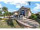 Inviting front yard with lush landscaping, a brick-paved sitting area and multiple chairs for relaxing at 2279 Lowell Ter, The Villages, FL 32162