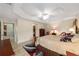 View of the main bedroom featuring a tray ceiling, ceiling fan, and ensuite bath with walk-in closet at 2279 Lowell Ter, The Villages, FL 32162