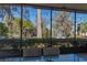 A screened porch with a table and chairs overlooking a lush garden at 2439 Cr 453, Lake Panasoffkee, FL 33538