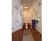 Compact powder room featuring decorative wallpaper, wood paneling, and a toilet at 25124 Twelve Oaks Rd, Leesburg, FL 34748