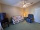 This is a tan bedroom with a ceiling fan, a love seat, recliner, and dresser at 25124 Twelve Oaks Rd, Leesburg, FL 34748