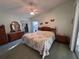 Bright bedroom with a large bed, light green walls, and a vaulted ceiling with a fan at 25124 Twelve Oaks Rd, Leesburg, FL 34748