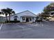 Community clubhouse with white exterior, covered porch, and ample parking at 25124 Twelve Oaks Rd, Leesburg, FL 34748