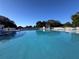 A lovely community pool surrounded by a white picket fence featuring chairs and gazebo at 25124 Twelve Oaks Rd, Leesburg, FL 34748