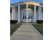 Stately building featuring a circular structure and large columns, offering a visually appealing and inviting entrance at 25124 Twelve Oaks Rd, Leesburg, FL 34748