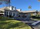 Exterior view of a white brick building with green shutters, manicured lawn, and covered entrance at 25124 Twelve Oaks Rd, Leesburg, FL 34748