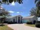 Attractive single-story home with a paved driveway, light blue accents and neat landscaping at 25124 Twelve Oaks Rd, Leesburg, FL 34748