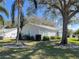 Well-maintained single-story home with light blue shutters surrounded by lush, mature landscaping at 25124 Twelve Oaks Rd, Leesburg, FL 34748