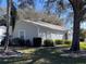 Single-story home with light blue shutters, complemented by mature landscaping and healthy green lawn at 25124 Twelve Oaks Rd, Leesburg, FL 34748