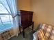 A wooden desk sits in a naturally lit room beside a sofa with plaid accents at 25124 Twelve Oaks Rd, Leesburg, FL 34748