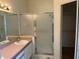 Bathroom with glass shower door, vanity, and walk-in closet entryway at 25212 Clifford Hl, Leesburg, FL 34748