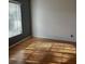 Bright bedroom with hardwood floors, grey accent wall, and natural light streaming through window at 25212 Clifford Hl, Leesburg, FL 34748