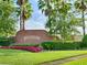 Sign for The Plantation at Leesburg with manicured lawn, red flowers, and trimmed hedges at 25212 Clifford Hl, Leesburg, FL 34748