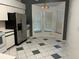 Eat-in kitchen area with checkerboard floors and stainless steel refrigerator at 25212 Clifford Hl, Leesburg, FL 34748