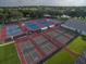 Aerial view of the community's multiple well-maintained tennis courts with blue and grey surfaces at 25212 Clifford Hl, Leesburg, FL 34748