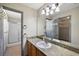 Bathroom featuring wood vanity, large mirror and tiled shower at 2541 Privada Dr, The Villages, FL 32162