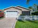 Inviting one-story home with attached garage, well-maintained lawn, and charming picket fence at 2667 Collington Dr, The Villages, FL 32162