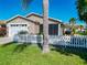 Inviting single-story home featuring a well-kept lawn and charming white picket fence at 2667 Collington Dr, The Villages, FL 32162