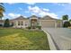 Charming single-story home with lush landscaping, a brick-paved driveway, and a well-manicured front lawn at 2882 Adrienne Way, The Villages, FL 32163