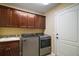 Well-equipped laundry room with modern appliances, cabinetry and a utility sink at 2882 Adrienne Way, The Villages, FL 32163